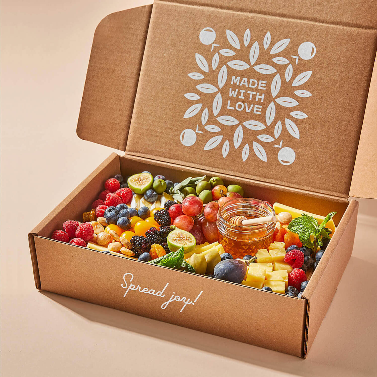 Angled view of an open medium Grazy box containing cheeses and fruits