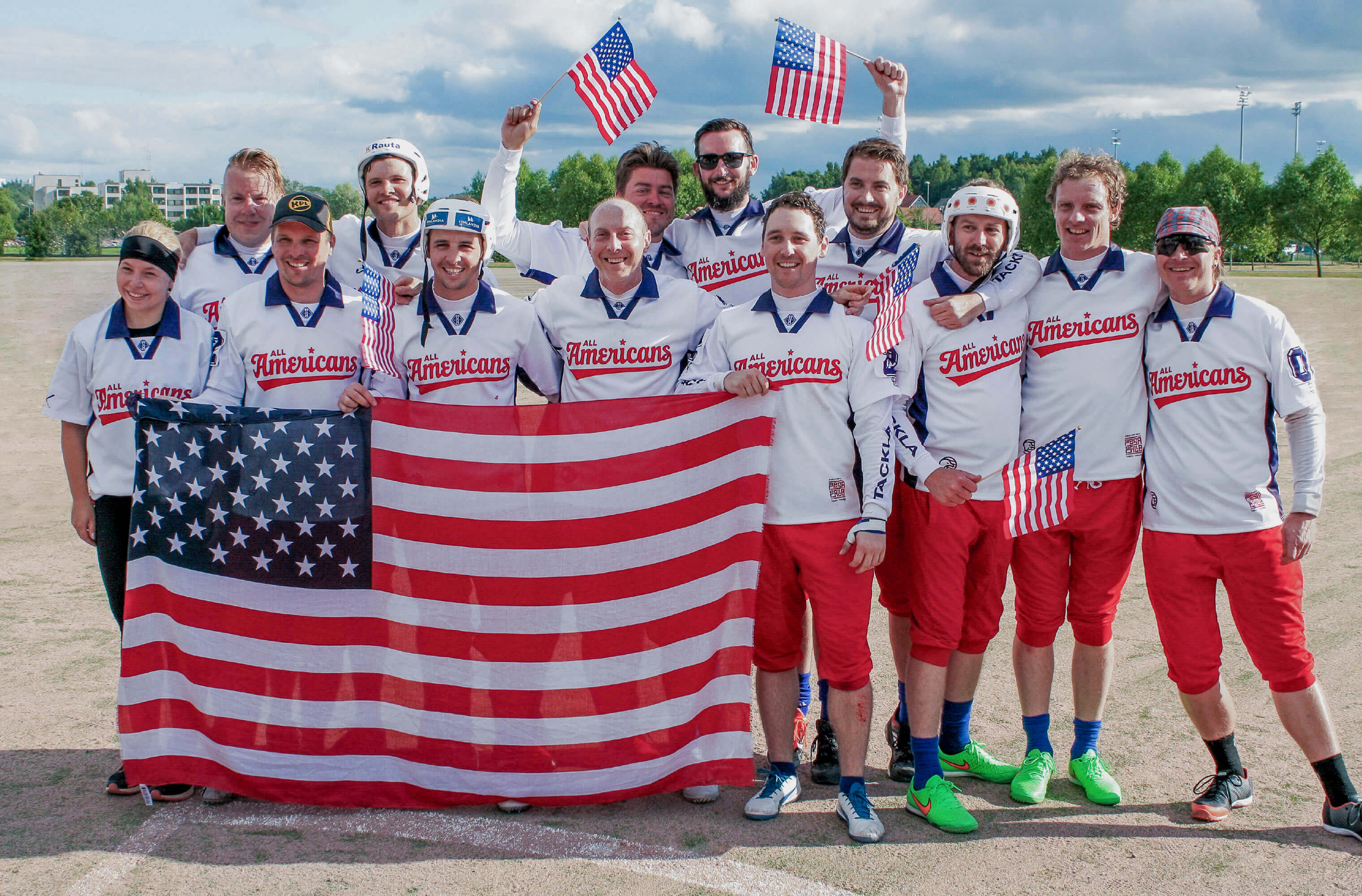 The All Americans team posing with American flags at the Pesäpallo World Cup