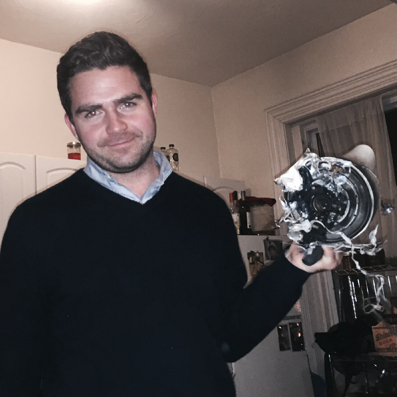 A guest holding up a melted electric kettle at a Condiments Club gathering