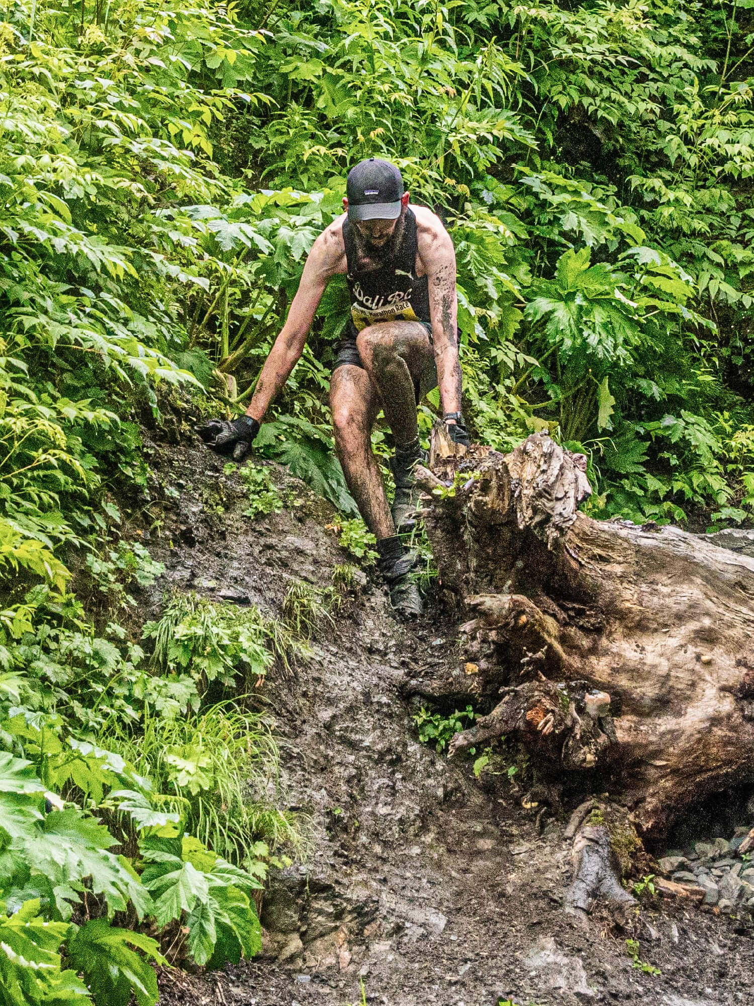 Dan scrambling over a fallen log in a DALI RC singlet during the mount marathon trail race