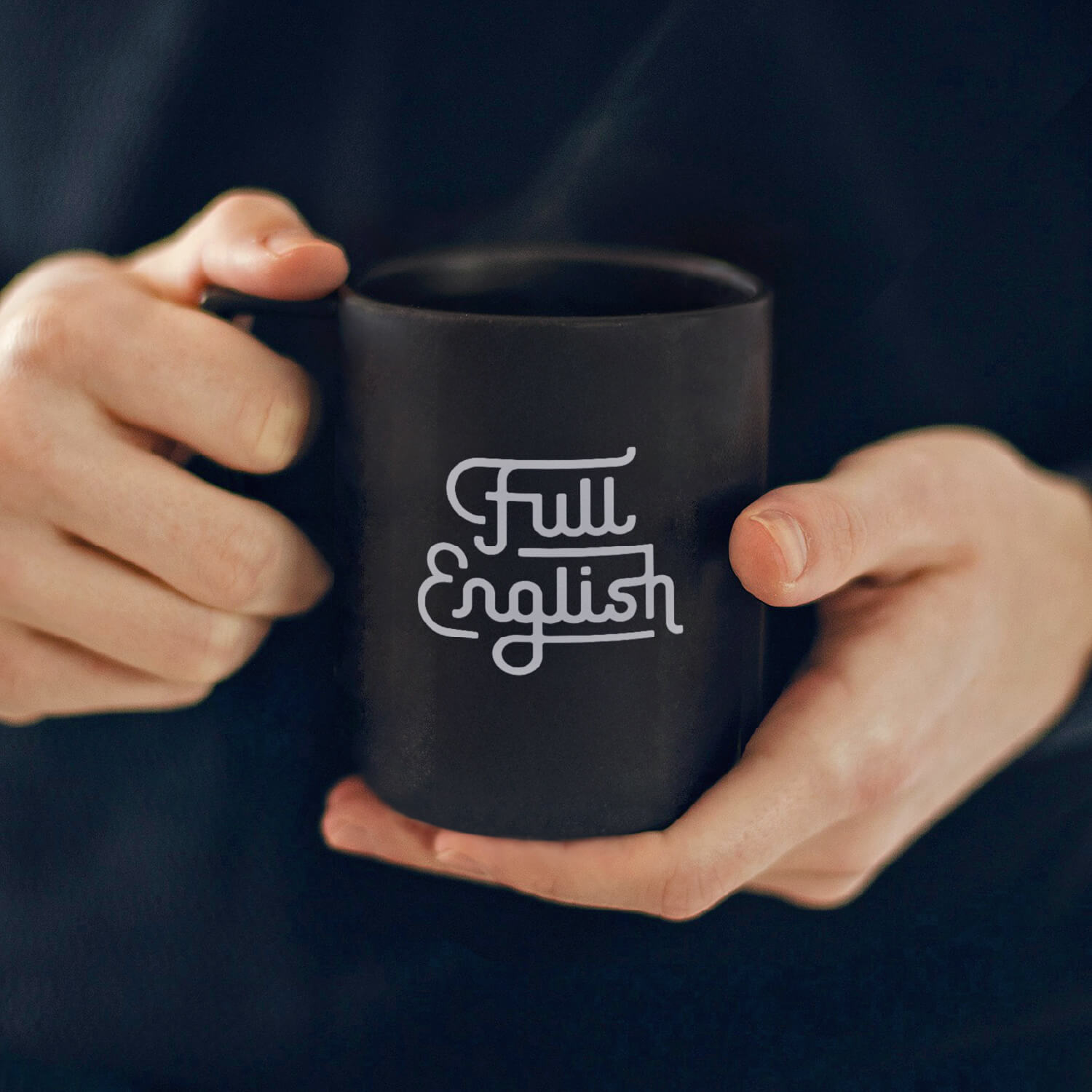 Hands holding a black Full English mug