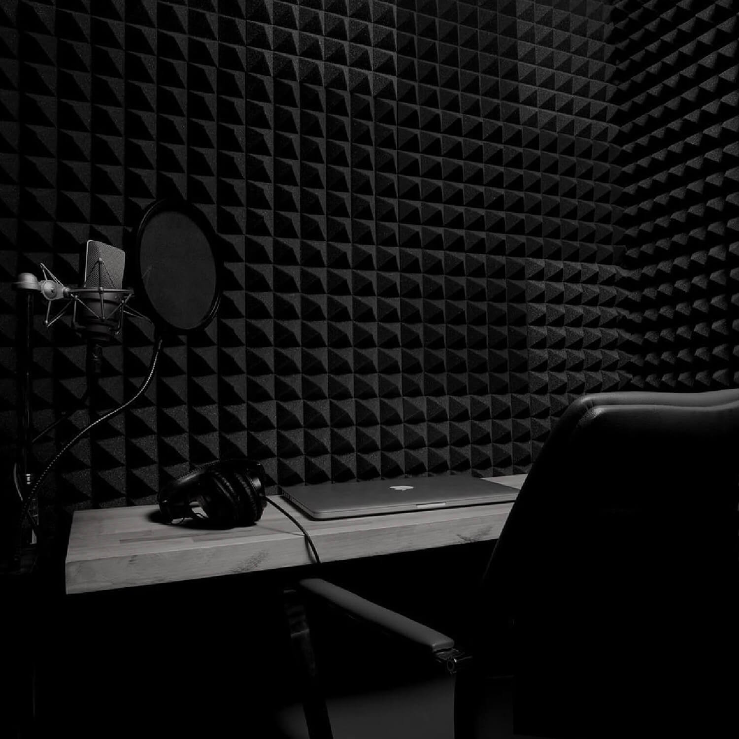 A microphone and headphones in a back sound-treated recording booth