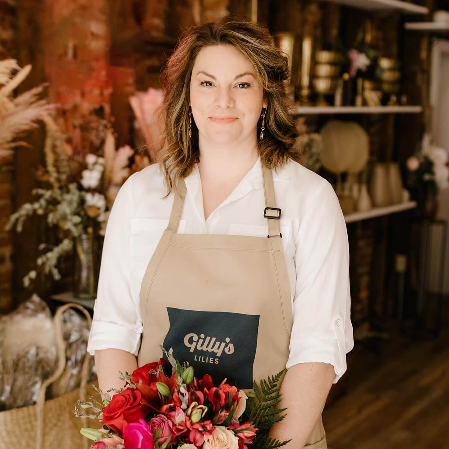 Founder Sarah Wheatley holding a bouquet in the Gilly's Lilies shop
